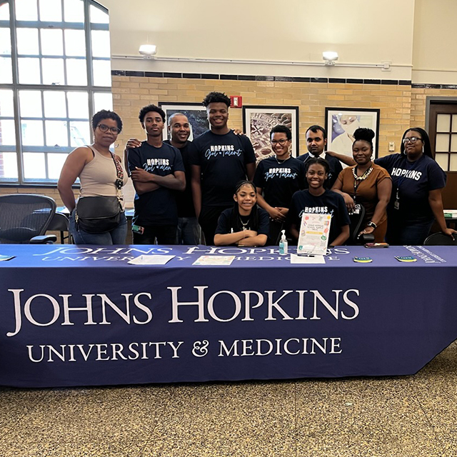 Interns from the 2023 Johns Hopkins Summer Jobs Program team up with members of The Community Group, Inc., to collect resources for city schools.