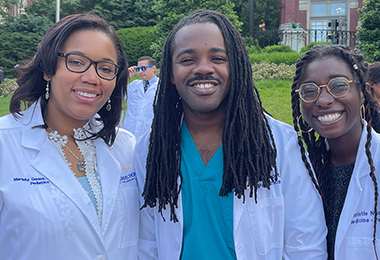 Three School of Medicine students stand together, smiling.