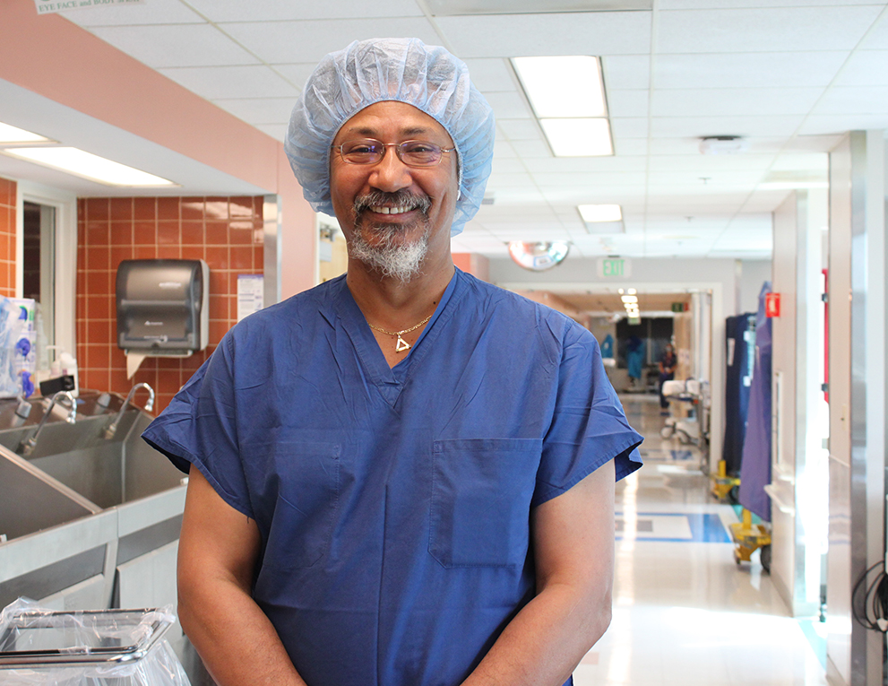 Allen Forney stands in a hallway in scrubs