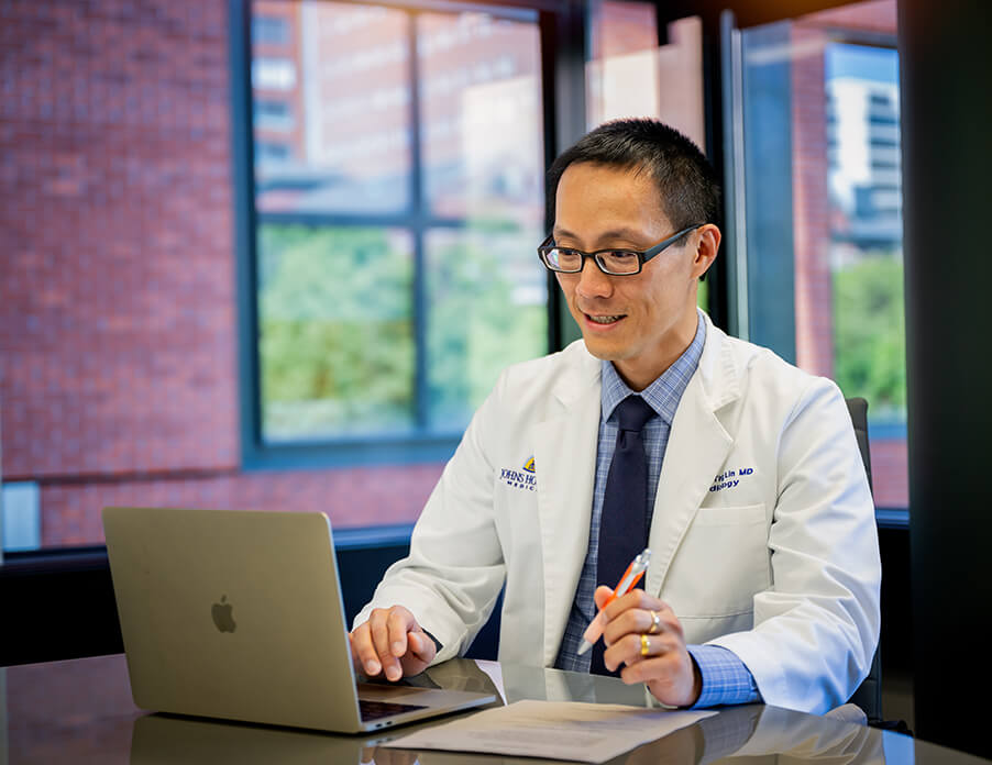 Man in white coat works at computer