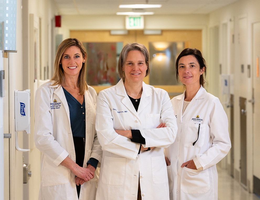 Three female doctors stand together. From left, Morgan Katz, Sara Cosgrove and Valeria Fabre, infectious disease physicians at The Johns Hopkins Hospital and the Johns Hopkins Bayview Medical Center.