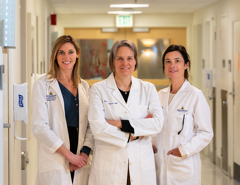 Three female doctors stand together. From left, Morgan Katz, Sara Cosgrove and Valeria Fabre, infectious disease physicians at The Johns Hopkins Hospital and the Johns Hopkins Bayview Medical Center.