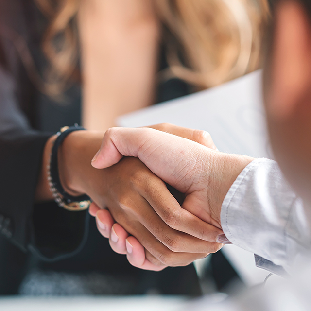 Two business professionals shake hands after an interview.