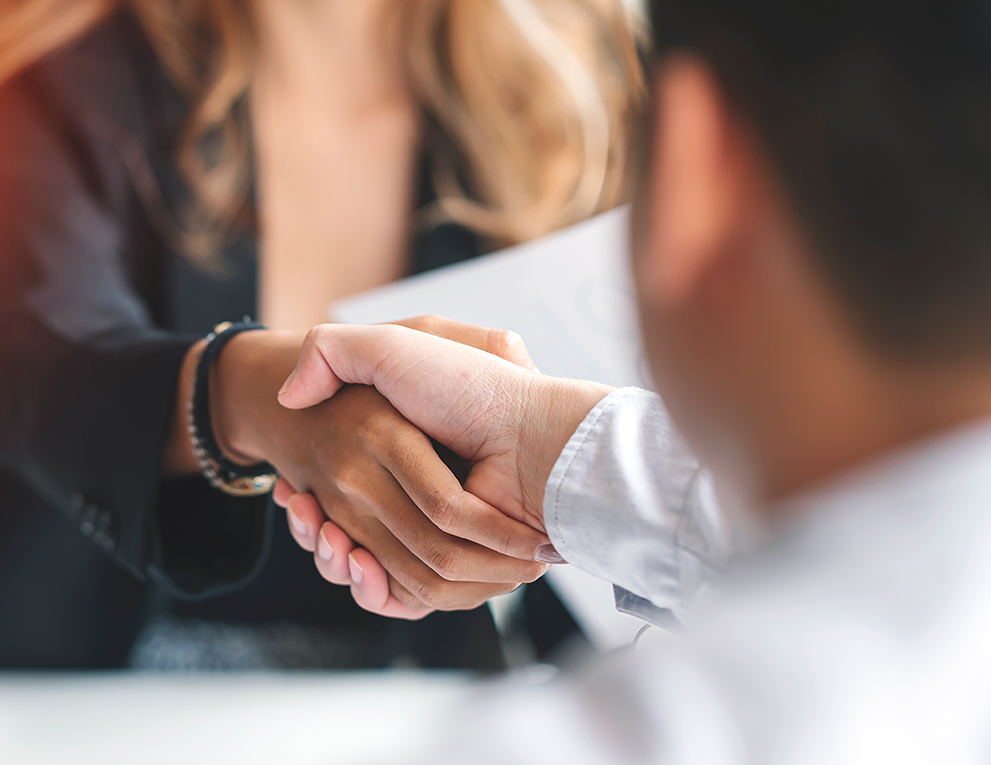 Two business professionals shake hands after an interview.