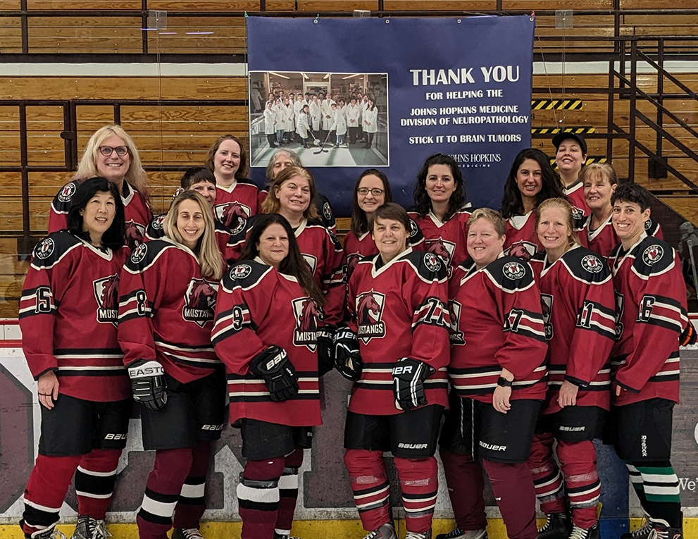 A team of female hockey players stand together.