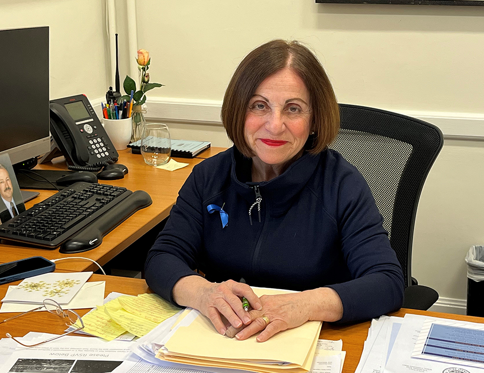 Toni Boucher sits smiling at her desk