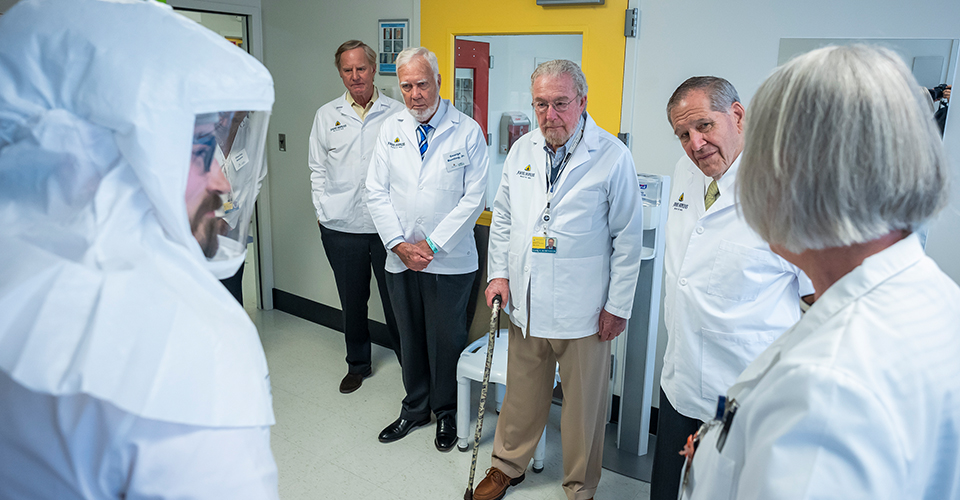 Members of the Dean’s Council peek inside the biocontainment unit.
