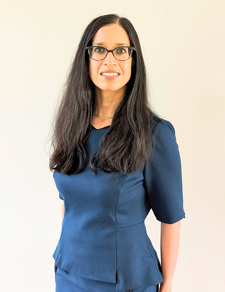 Janet Rathod Stands in a blue dress.