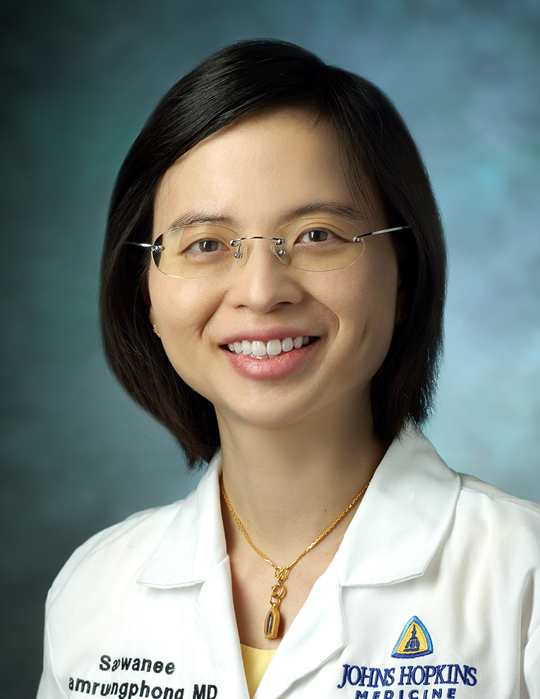 Dr. NGAMRUENGPHONG smiles against a plain background.