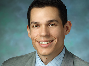 Formal portrait of Jospeh McGuire wearing a gray suit