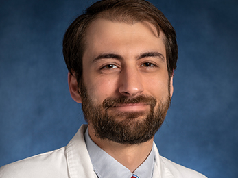 Formal portrait of Zachariah Foda wearing a white lab coat