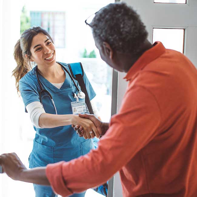 Nurse greets patient at his front door