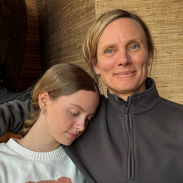 A resting daughter rests her head on her mom's shoulder.