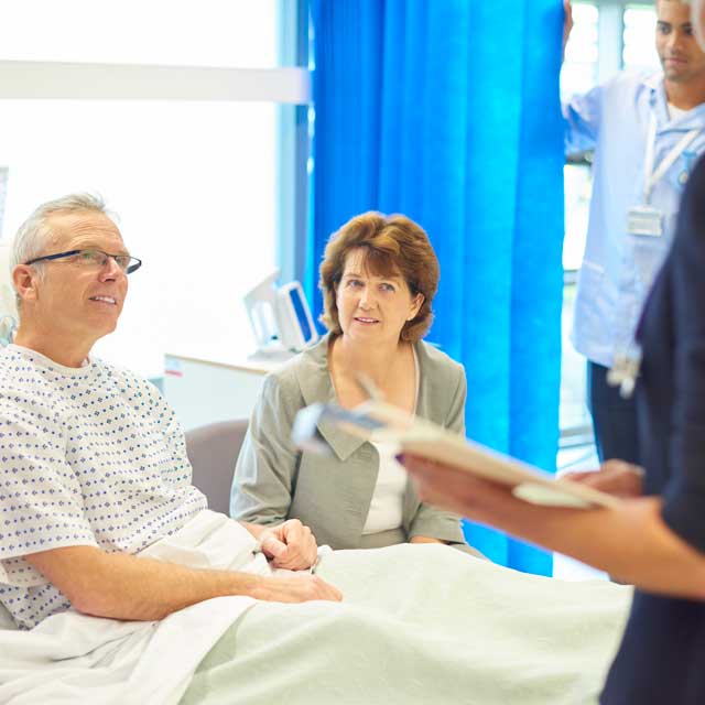 Surgery patient with his wife talking with his care team