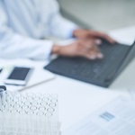 Researcher typing on laptop in lab