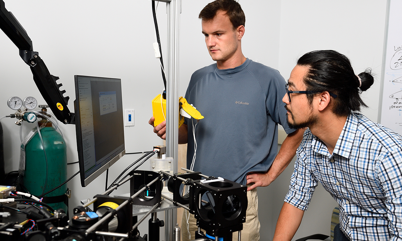 Grant Kroeschell, left, in the lab with Wilmer’s Ji Yi, an optical engineer.