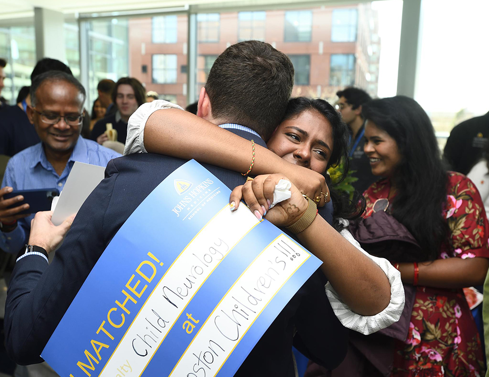 Doctor hugs family after match day 