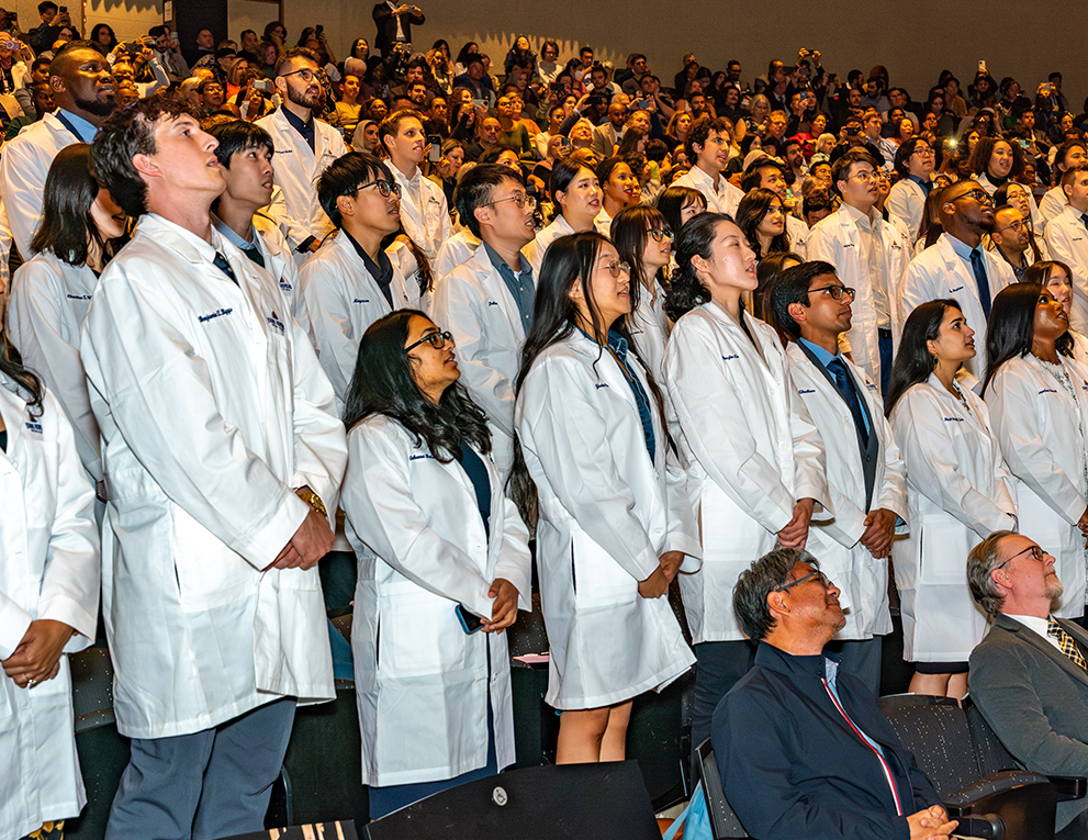 Doctors stand for the white coat ceremony