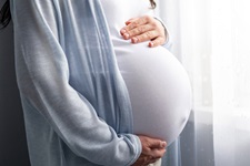 pregnant woman stands by window