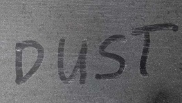 a dusty table with the word dust spelled out