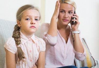 sick child with her mother in the phone