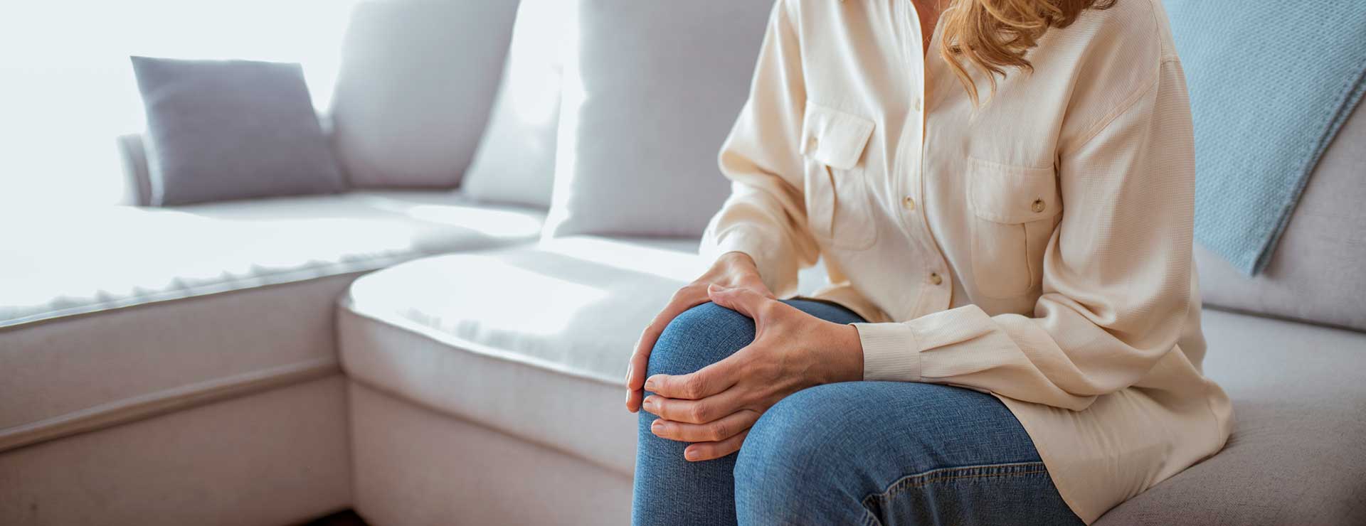 Older woman holding knee in pain.