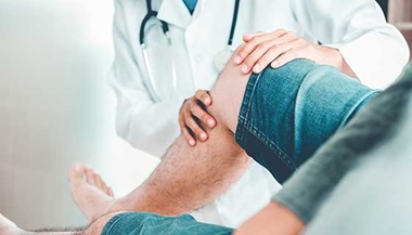 Doctor examining a patient's knee.