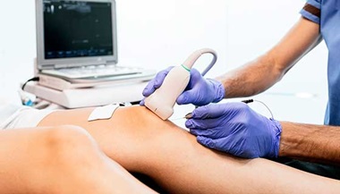 A doctor giving a patient knee therapy.