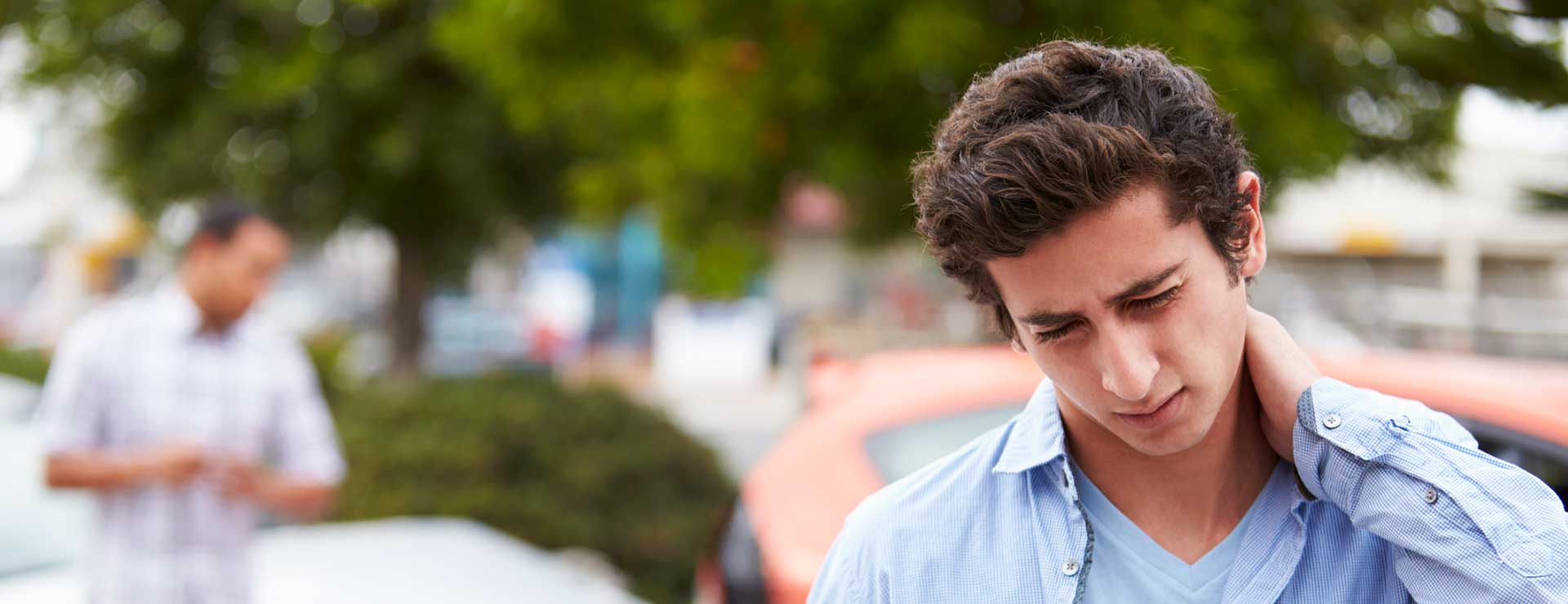 Young man holding neck in pain after car accident.