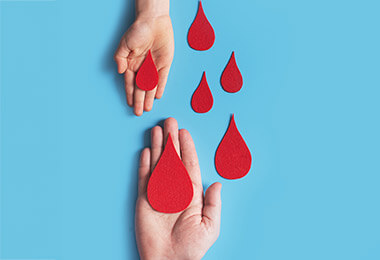 hands reaching out for red paper cutouts signifying drops of blood