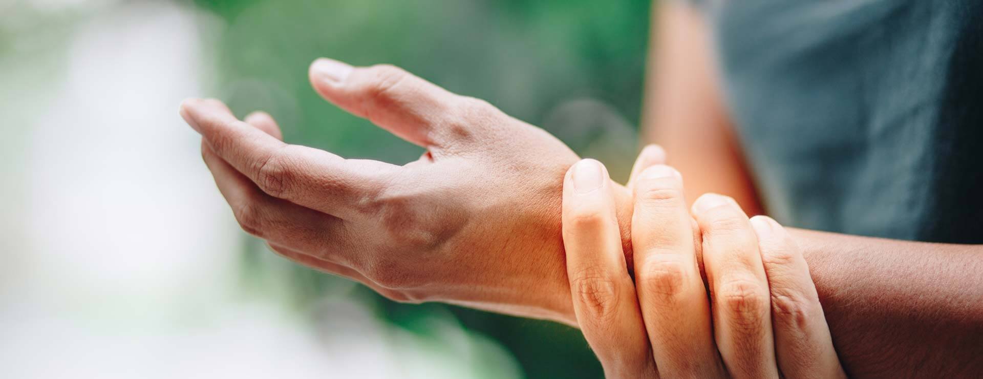 Person holding wrist that has pain