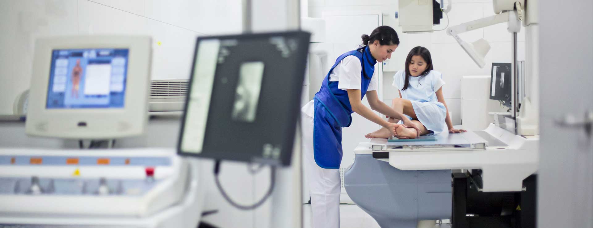 Healthcare provider performing a bone scan on a patient's leg.