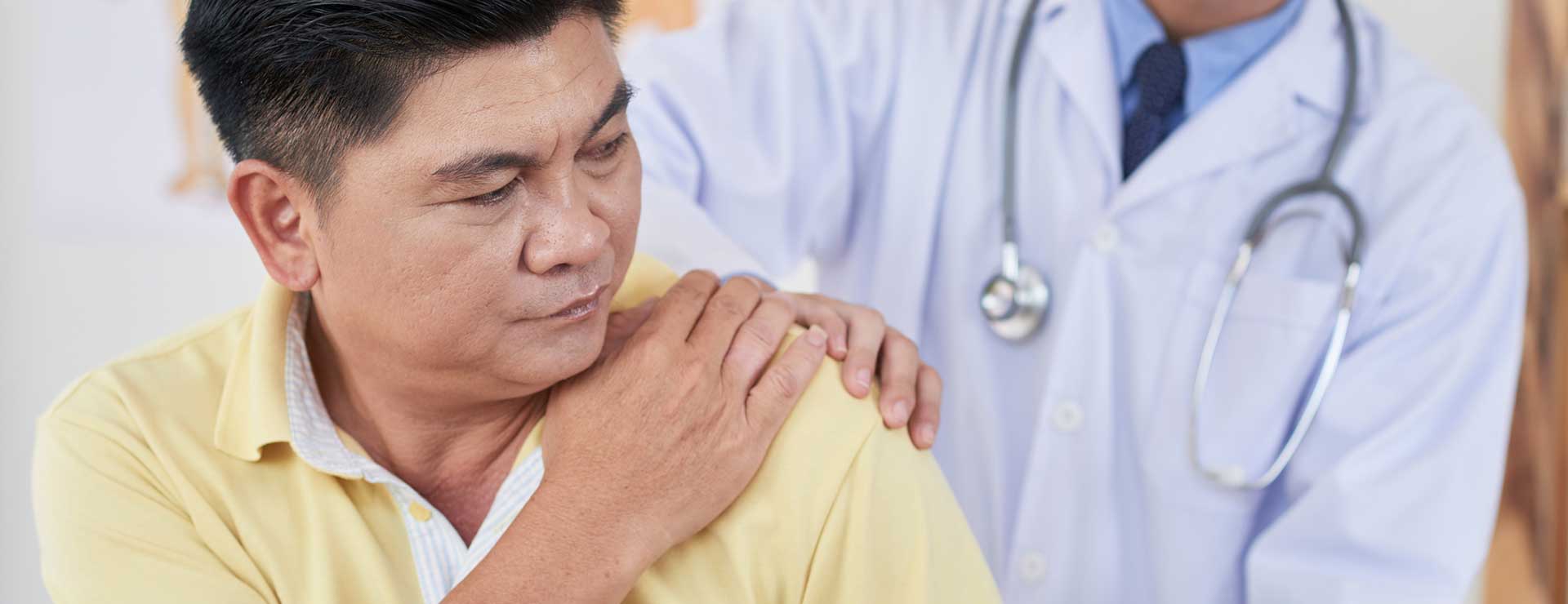 Doctor examining a patient's shoulder.