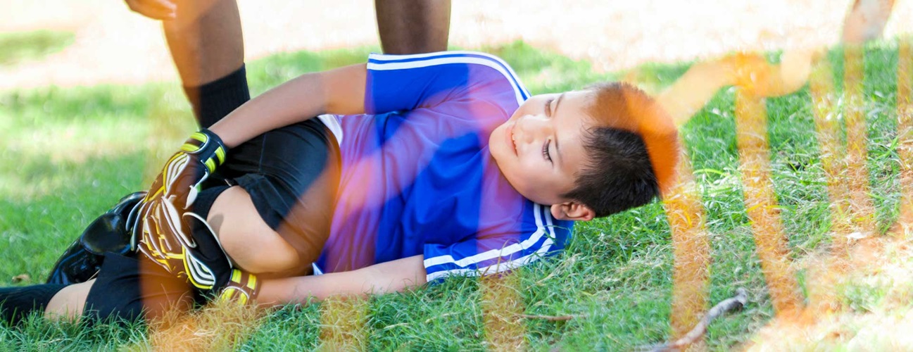 Child with injured knee at soccer game.