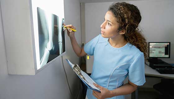 Healthcare provider looking at x-ray of a patient's leg.