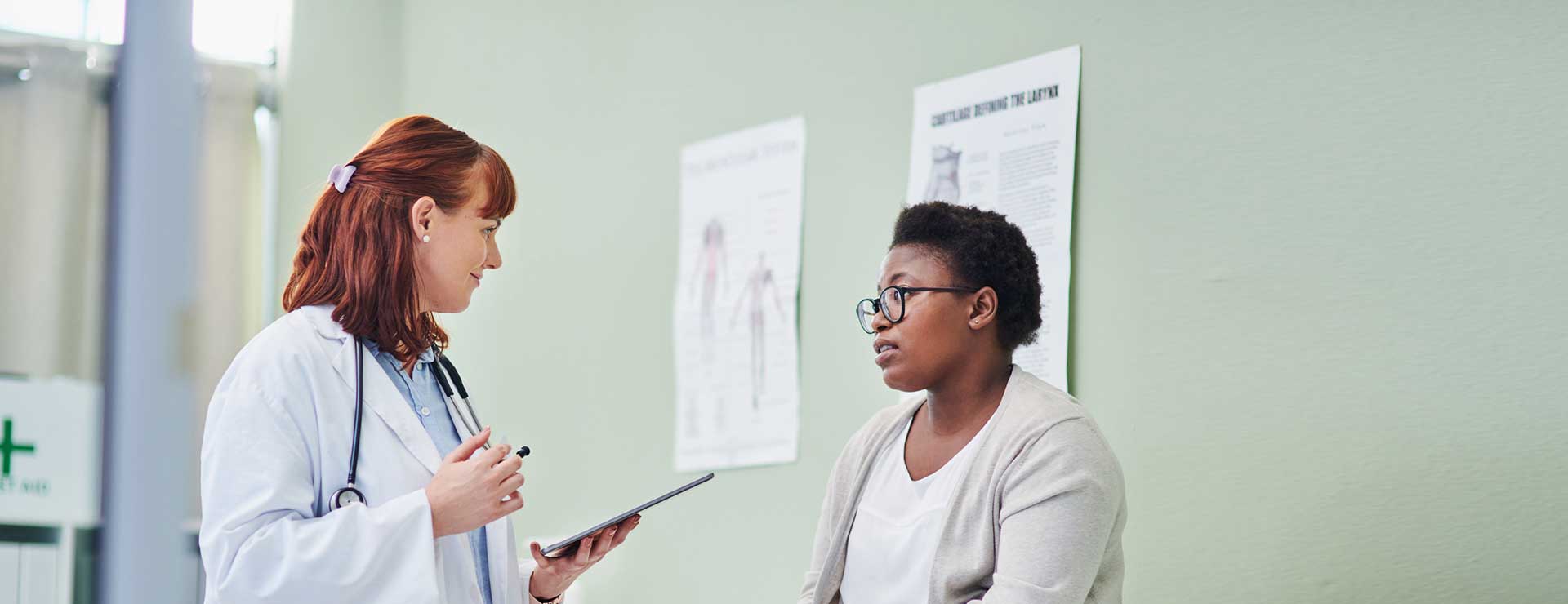 Patient discusses her concerns with her doctor in an exam room