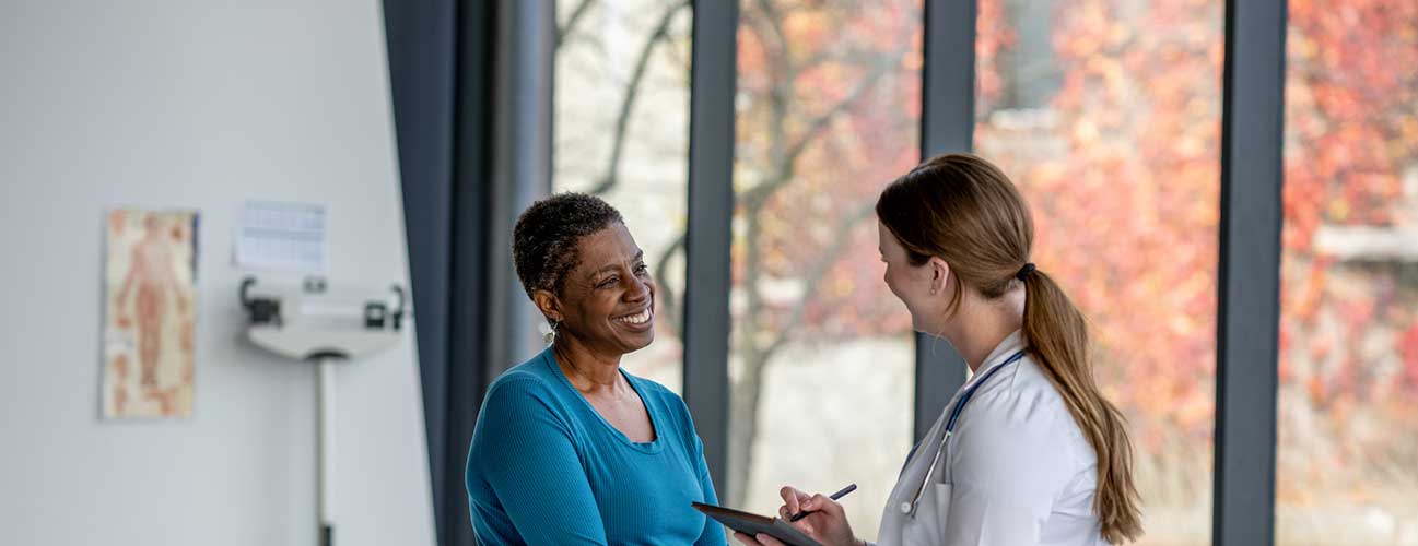 Doctor and patient speak in a brightly room
