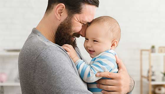 dad holding his baby and smiling
