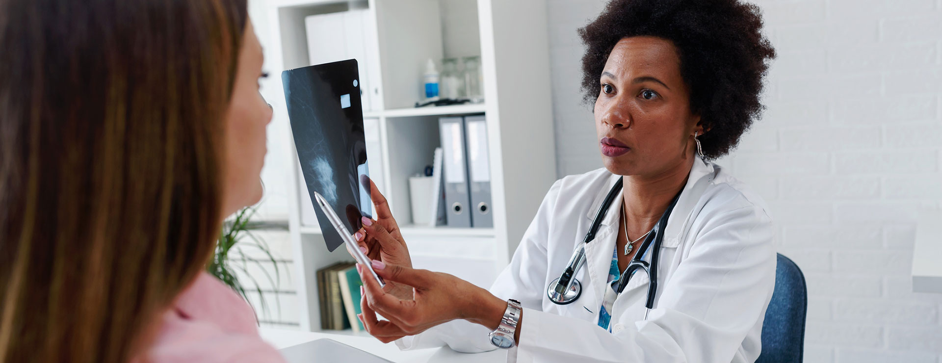 A doctor explains a mammogram to a patient