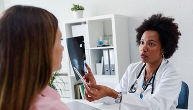 A doctor explains a mammogram to a patient