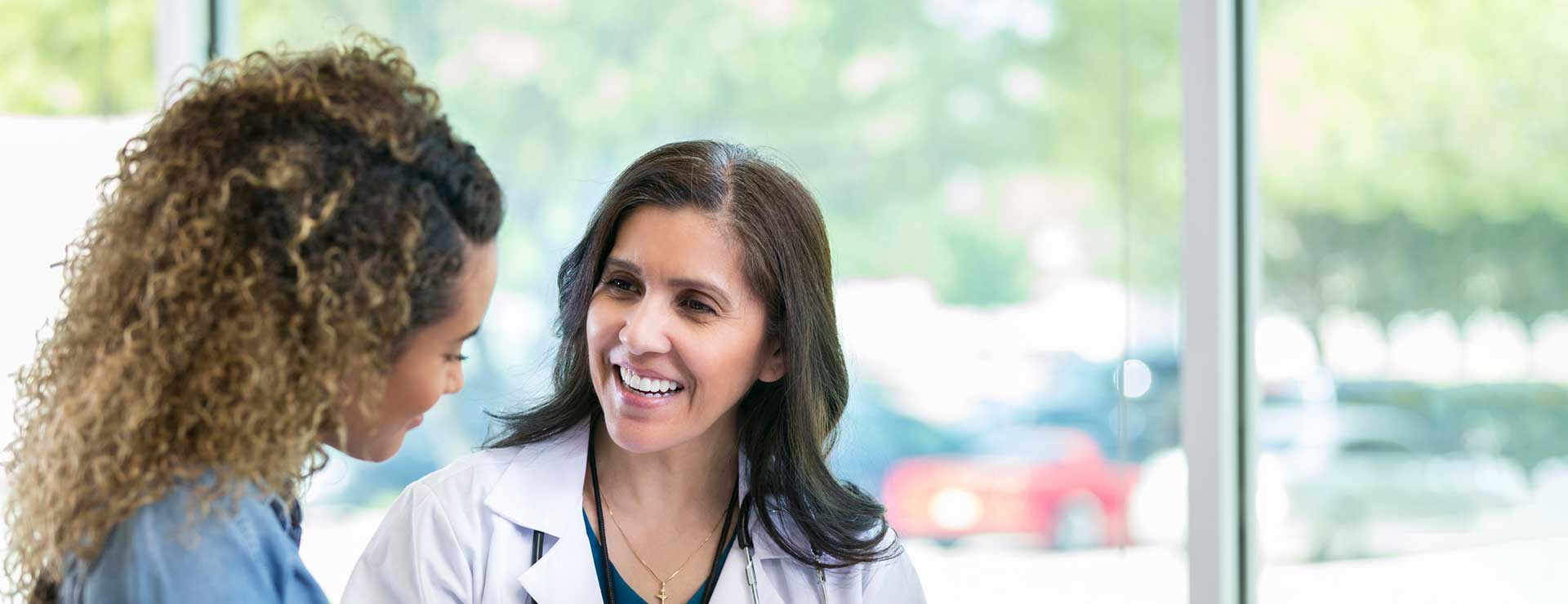 A doctor speaks with a young woman.