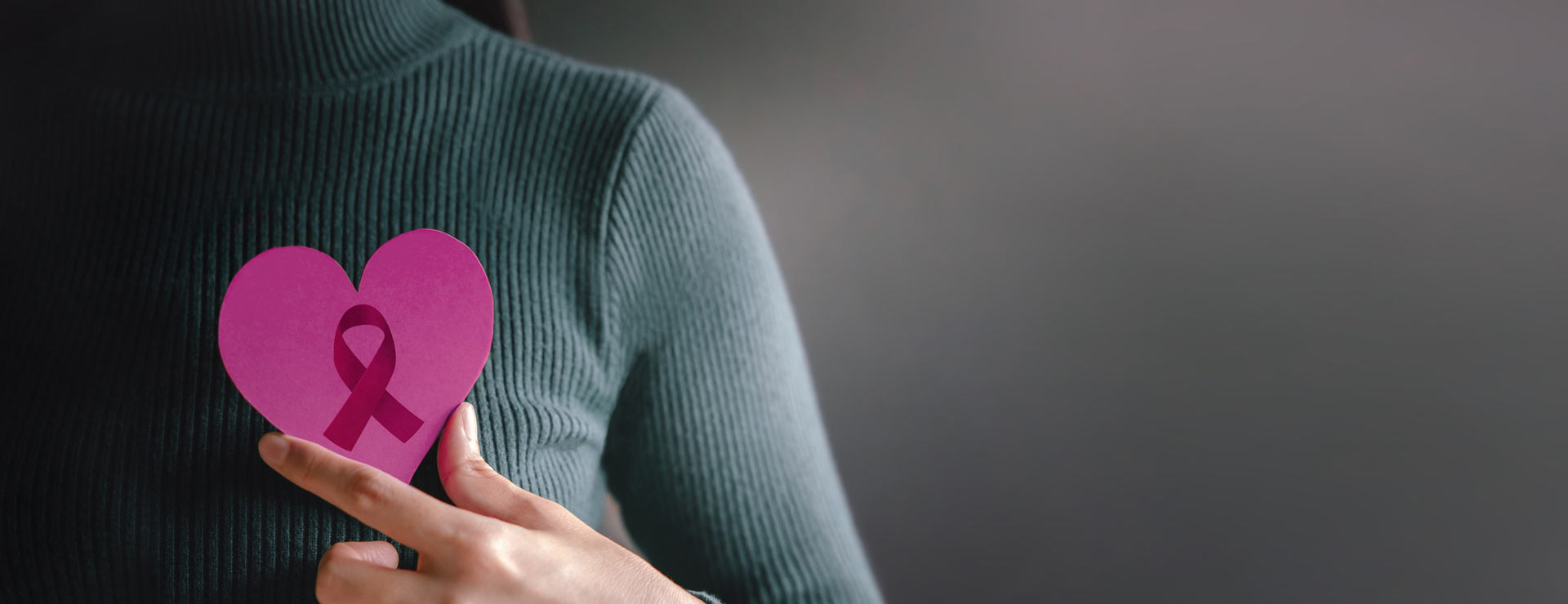 Woman holding up breast cancer awareness ribbon