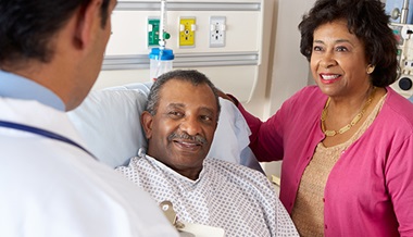 Patient in the hospital with his spouse talking to the doctor