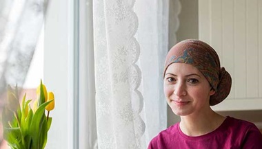 Woman with headscarf sitting by window