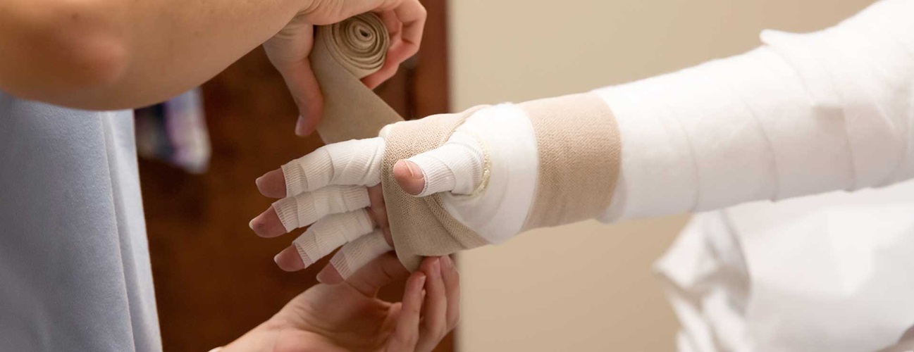A lymphedema patient gets their arm bandaged.