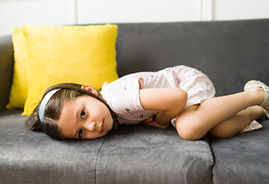 A child lies on a couch as she prepares for an appendectomy for children.
