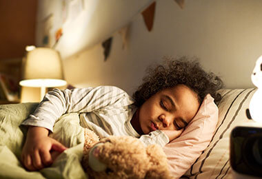 a child cuddling with a teddy bear in bed