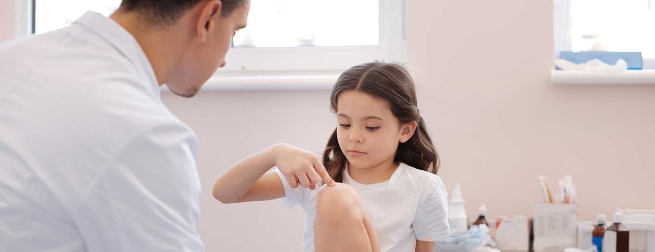 Child telling doctor symptoms of knee