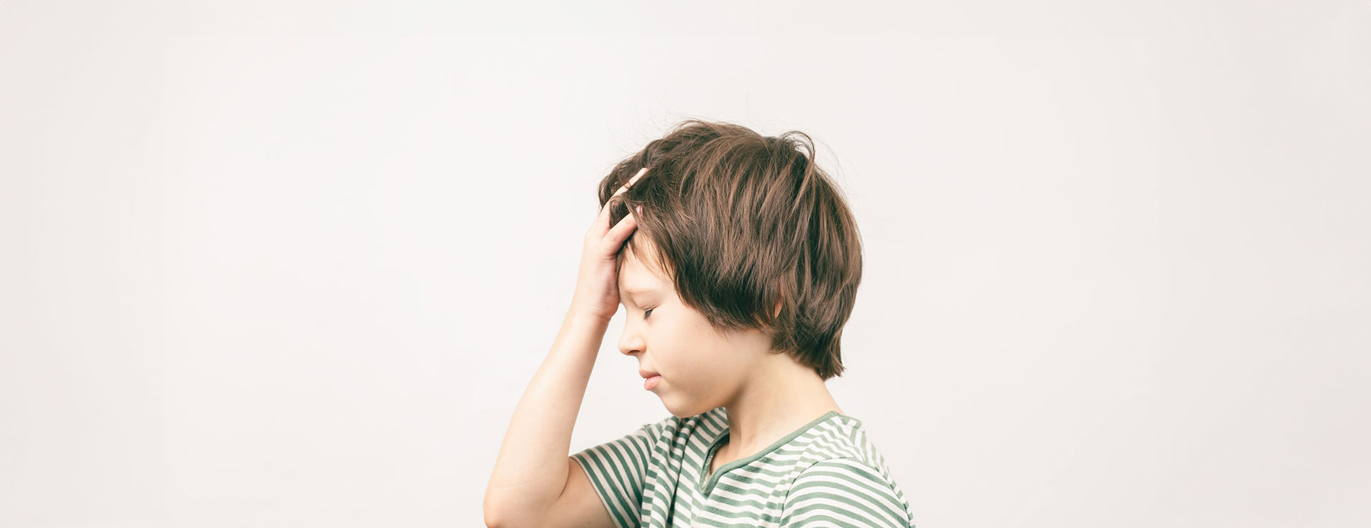 boy holds his head as he thinks about child safety