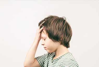 boy holds his head as he thinks about child safety